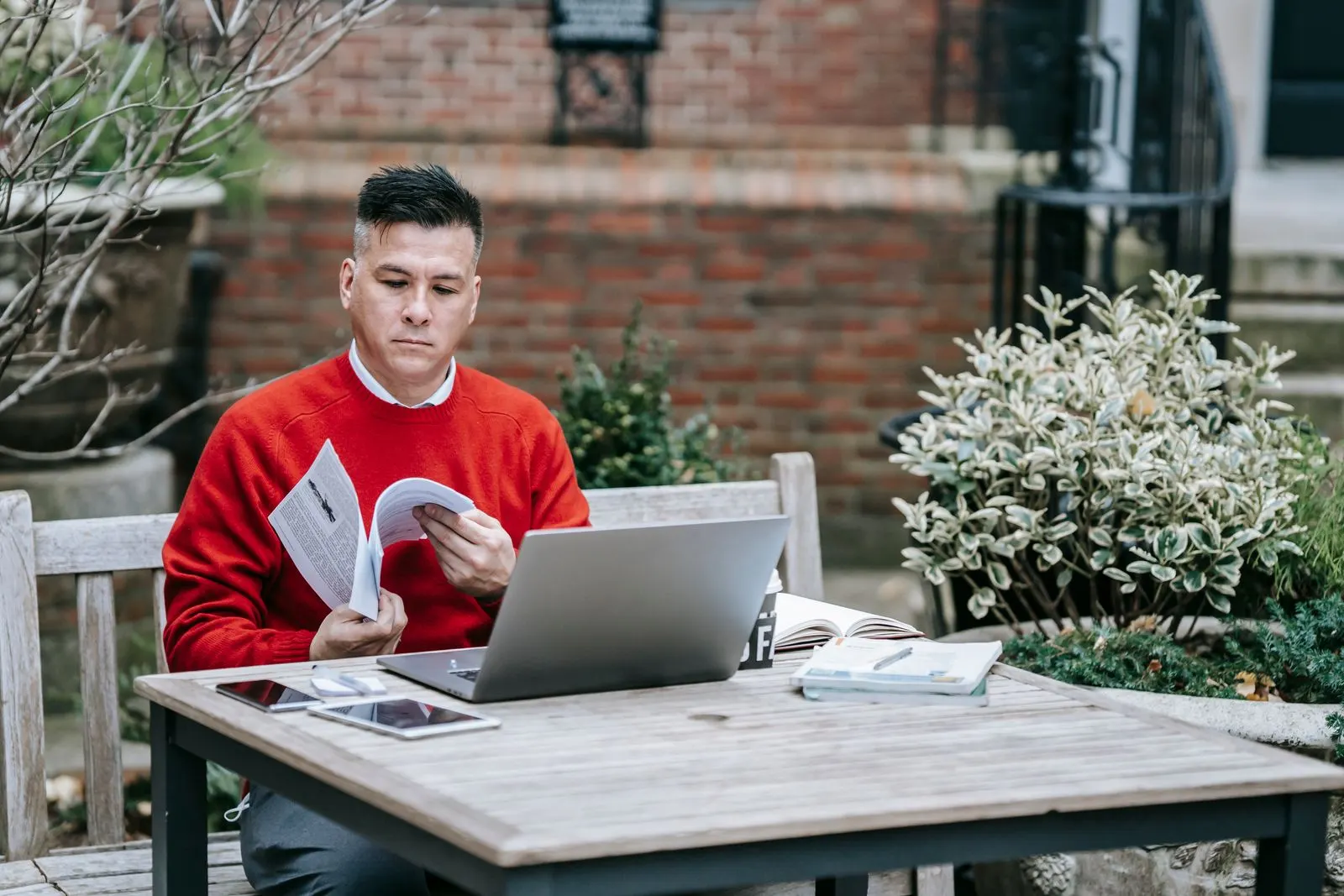 A business owner reviews a report next to his laptop